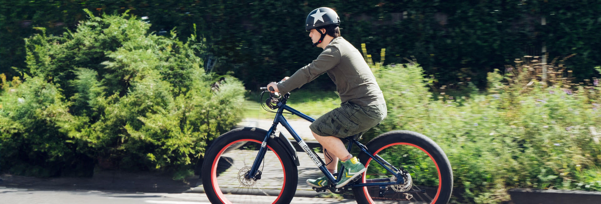 Ein junger Mann mit Behinderung fährt mit dem Fahrrad.